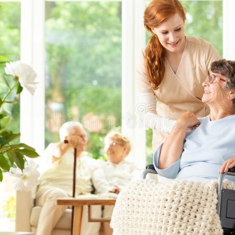 tender-caregiver-saying-goodbye-to-elderly-pensioner-whe-wheelchair-day-care-facility-companion-pushing-other-people-121130396